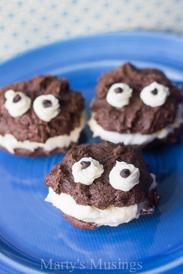 A large chocolate cake on a blue plate, with Cookie Monster