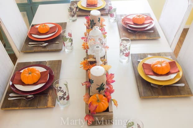 A bowl of oranges on a table, with Thanksgiving and Plate