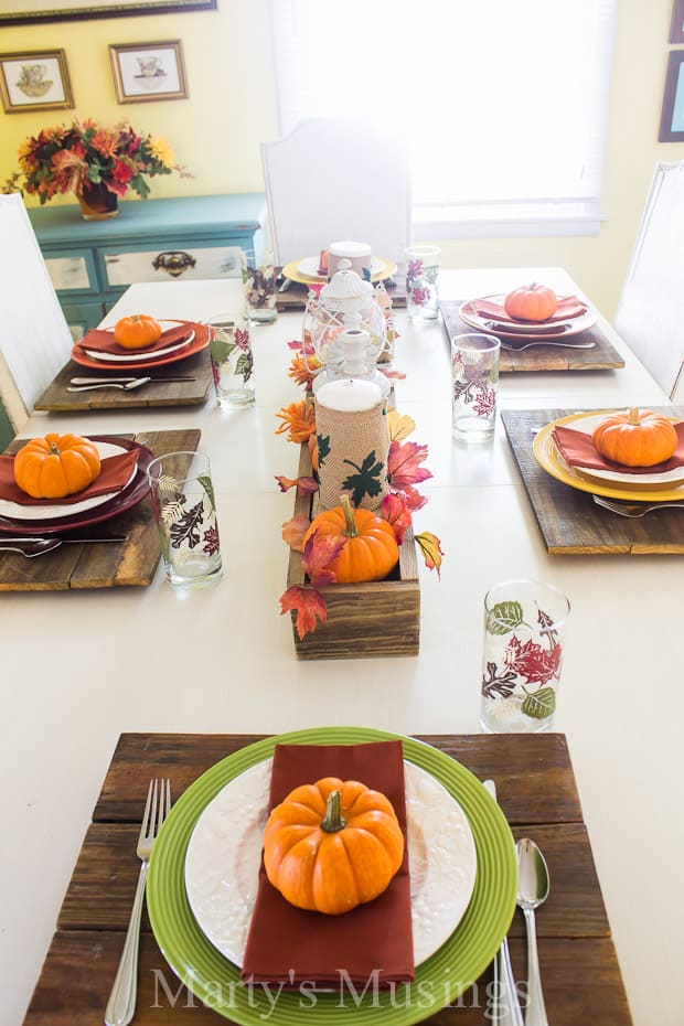 A wooden table topped with plates of food on a plate, with Thanksgiving and Glass