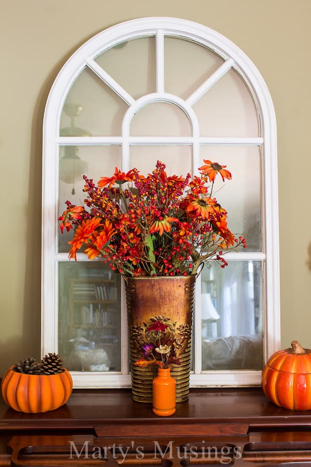 A vase of flowers sits in front of a window