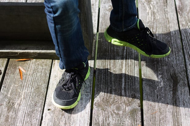 A pair of feet standing on a wooden bench