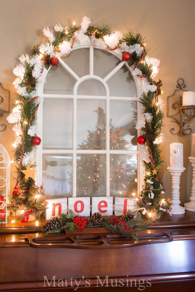 A vase of flowers on a table next to a christmas tree