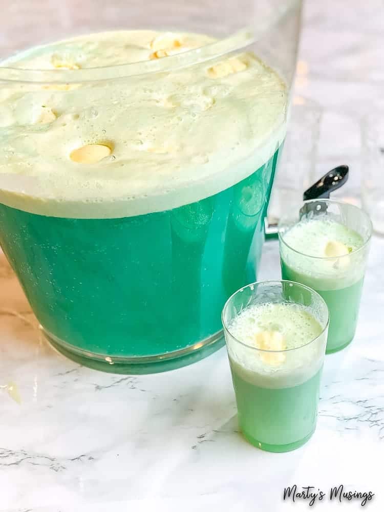 Glass punch bowl with blue frozen punch and vanilla ice cream