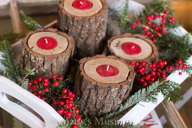 Log candle holders gathered on white tray for Christmas