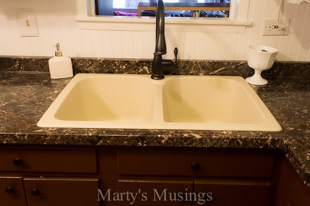 A kitchen with a sink and a mirror