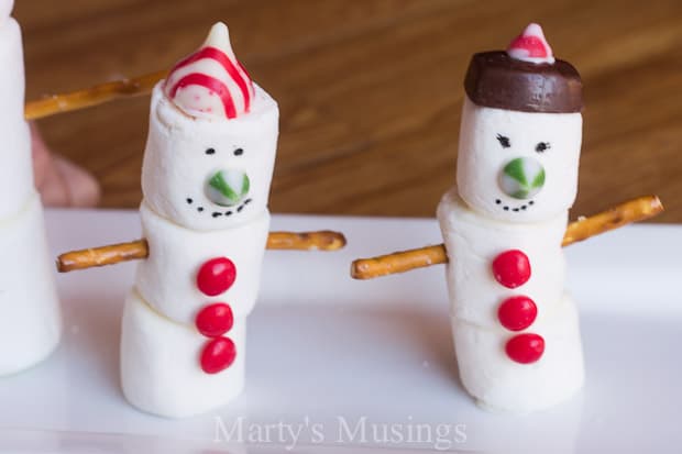 Two marshmallow snow children with edible decorations