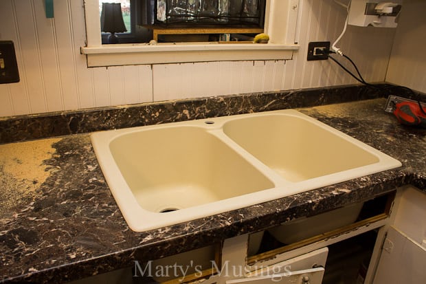 A counter with a sink and a mirror