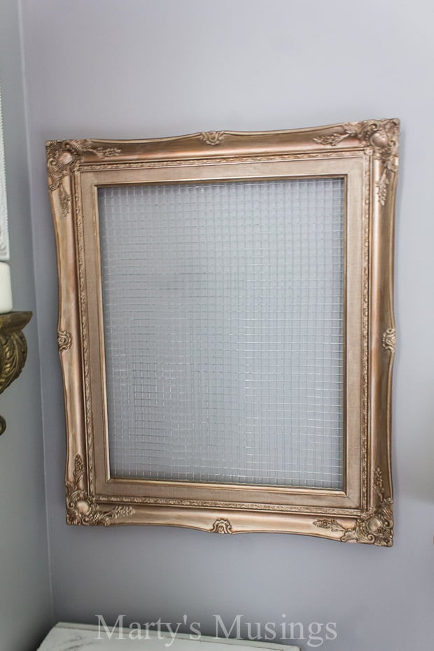 Gold vintage frame with chicken wire hanging on wall
