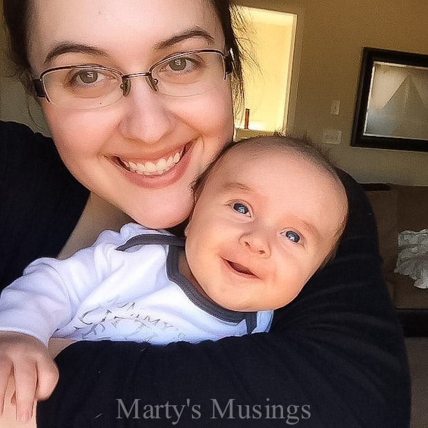 A person holding a baby posing for the camera