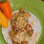 A bowl of food on a plate, with Fruit and Chicken