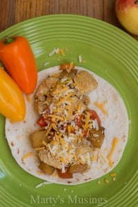 A bowl of food on a plate, with Fruit and Chicken