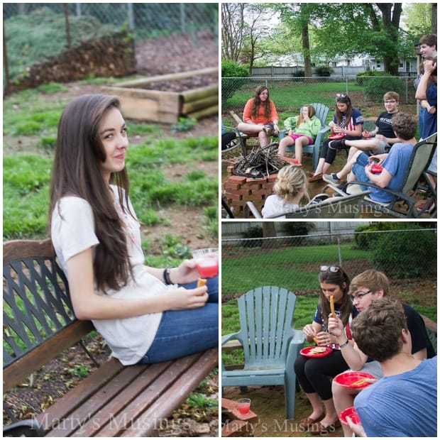 A group of people sitting on a bench outside at a party