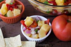 A bowl of food on a table, with Pineapple and Salsa