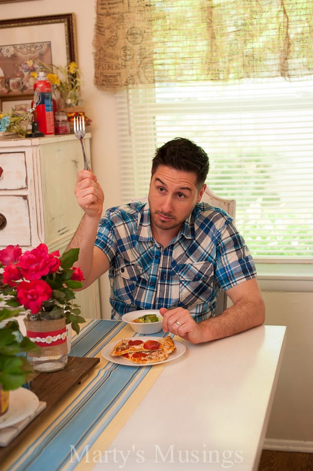 A person sitting at a table eating pizza