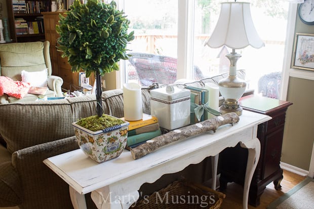 A living room filled with furniture and vase on a table