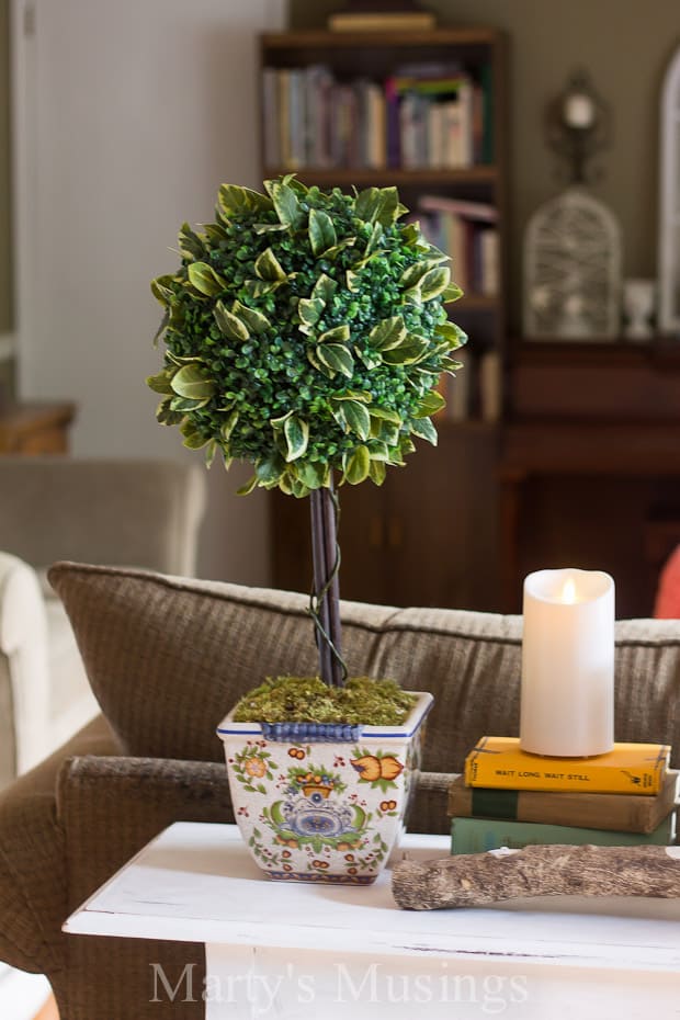 A living room filled with furniture and vase of flowers on a table