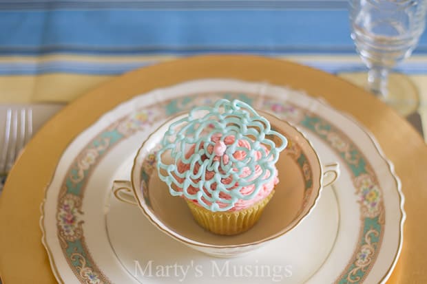 A table with a cake on a plate, with Cupcake