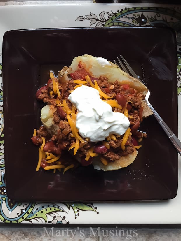 Using common everyday ingredients this easy Slow Cooker Chili by Marty's Musings tastes delicious served over a baked potato or by itself topped with sour cream and cheese.