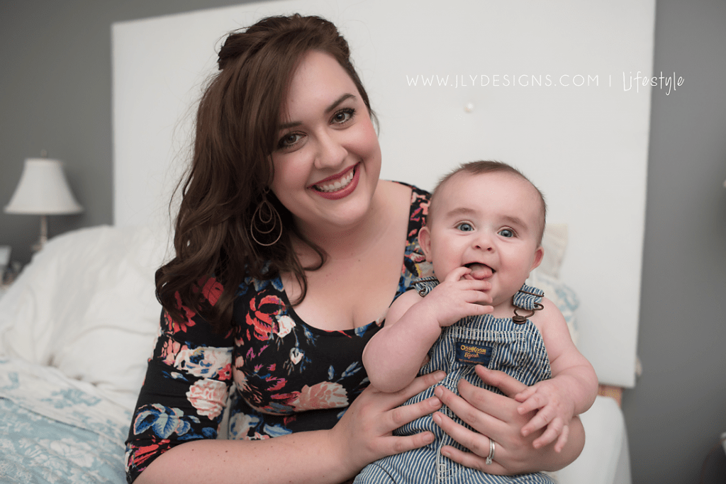 A woman holding a baby posing for the camera