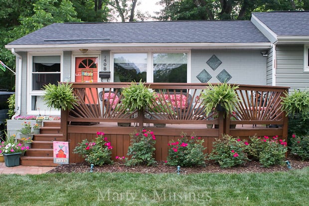 Red roses and ferns in front of sunburst deck railing