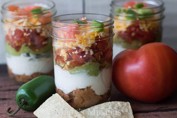 This Seven Layer Dip in a half pint sized mason jar looks adorable and tastes great! Perfect for any party or family gathering this mexican meal in a jar is both healthy and fun! It's also perfect for a make ahead lunch.