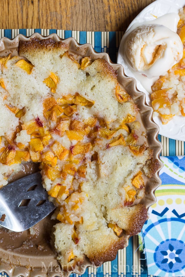 Peach cobbler in pie pan with ice cream