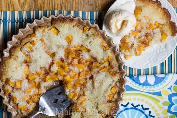 Peach cobbler in pan with vanilla ice cream on the side