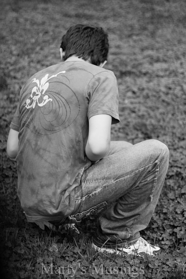 A young boy sitting in a field