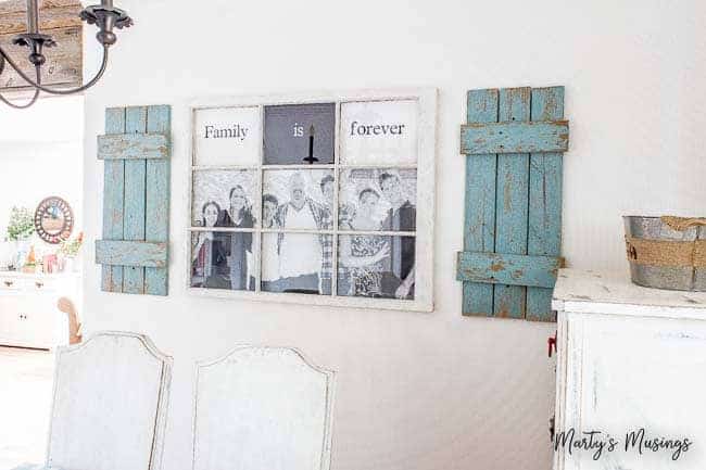 Family is forever sign in window glass with blue shutters