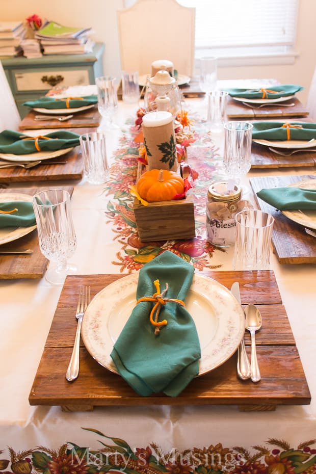 A wooden cutting board with a cake on a table, with Thanksgiving and Family