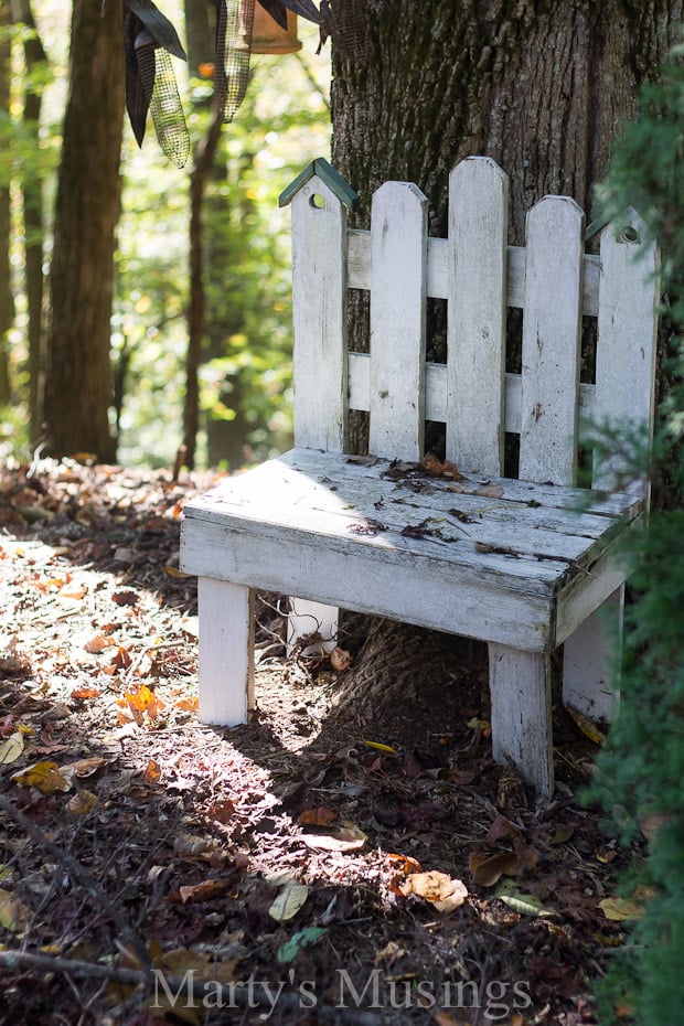 A wooden bench sitting next to a forest