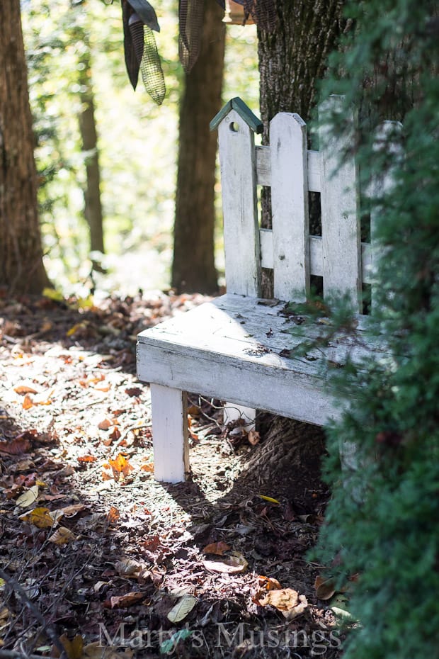 A stone bench sitting next to a forest