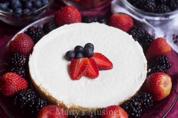 A cake with fruit on a plate, with Whipped cream