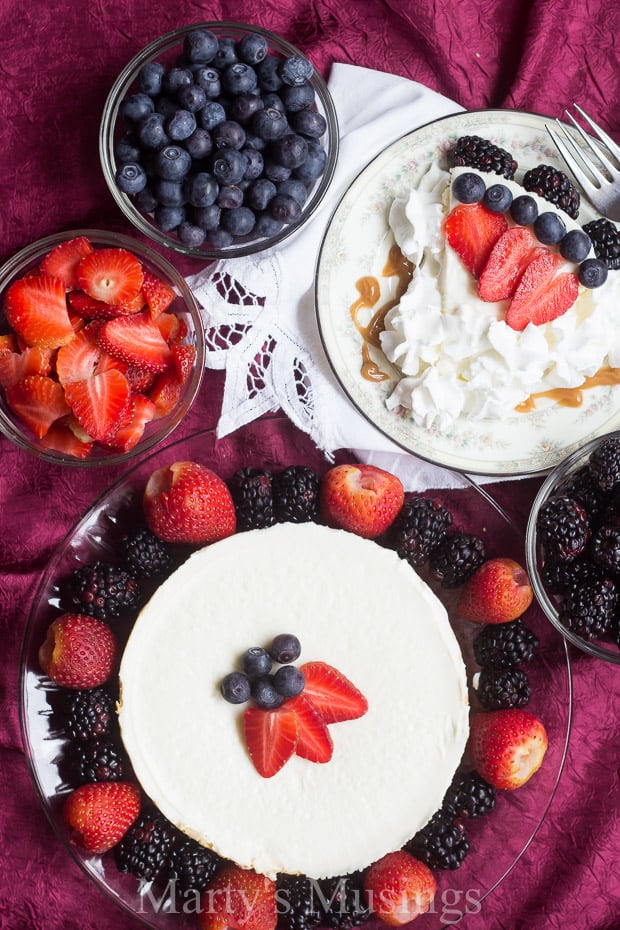 A cake with fruit on top of a plate of food, with Whipped cream