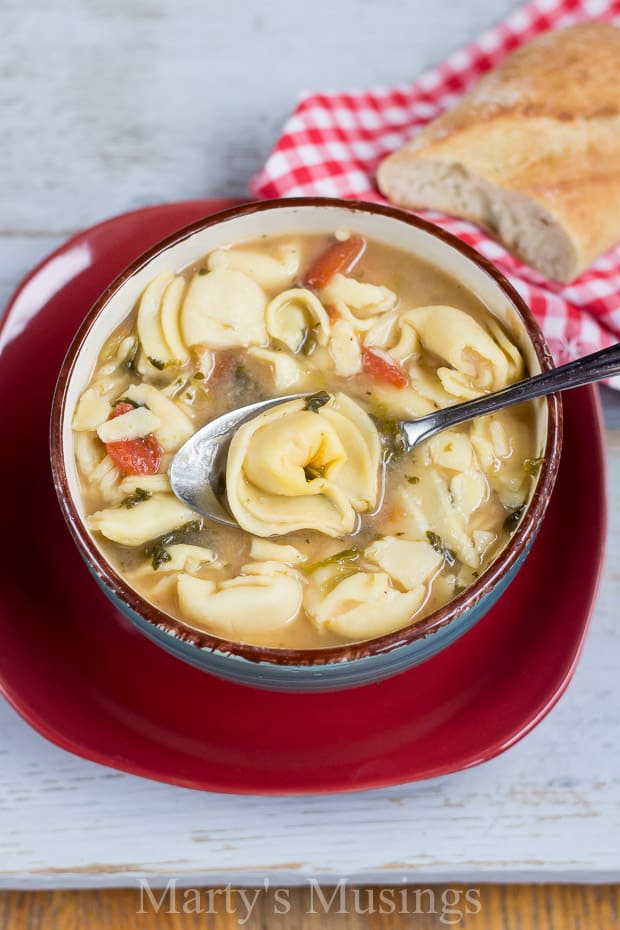 A bowl of food on a plate, with Soup and Cheese