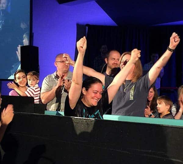 A group of people on a stage with a crowd watching