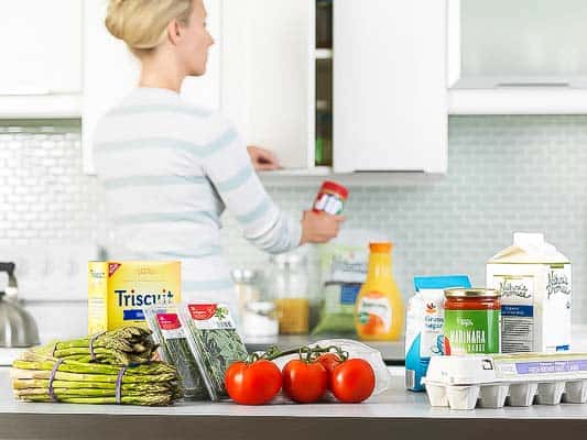A person sitting on a kitchen counter preparing food, with Delivery and Peapod