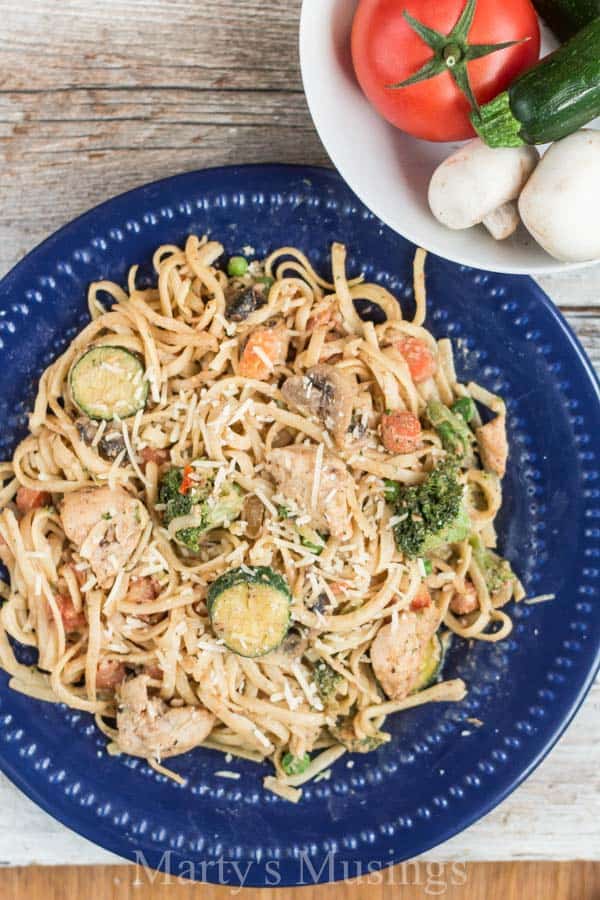 A bowl of food on a plate, with Pasta primavera