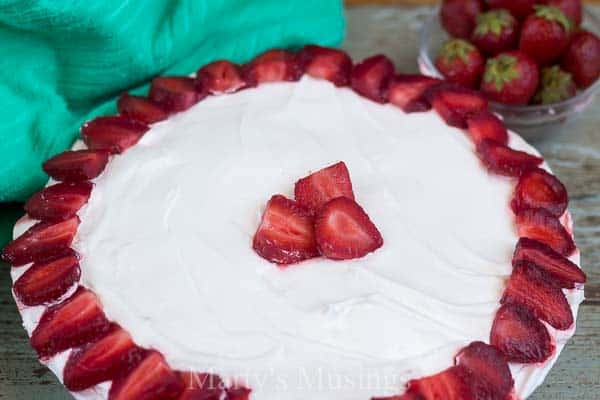 A cake with fruit on a plate, with Strawberry