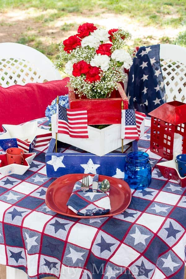 Red white and blue stars on tablecloth with red dishes and flowers