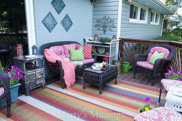 Front deck filled with furniture and colorful pillows and flowers