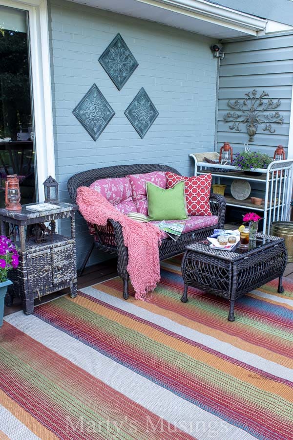 Colorful patterned rug on front deck with rustic furniture