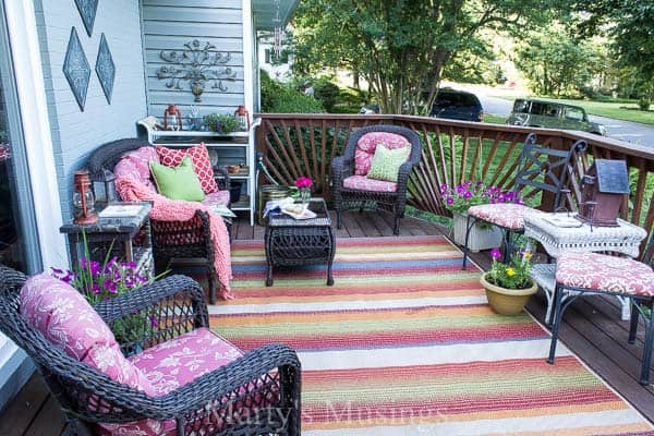 Try these 5 deck decorating ideas on a budget to create a gorgeous outdoor room with an area rug, throw pillows, flowers and inexpensive accessories.