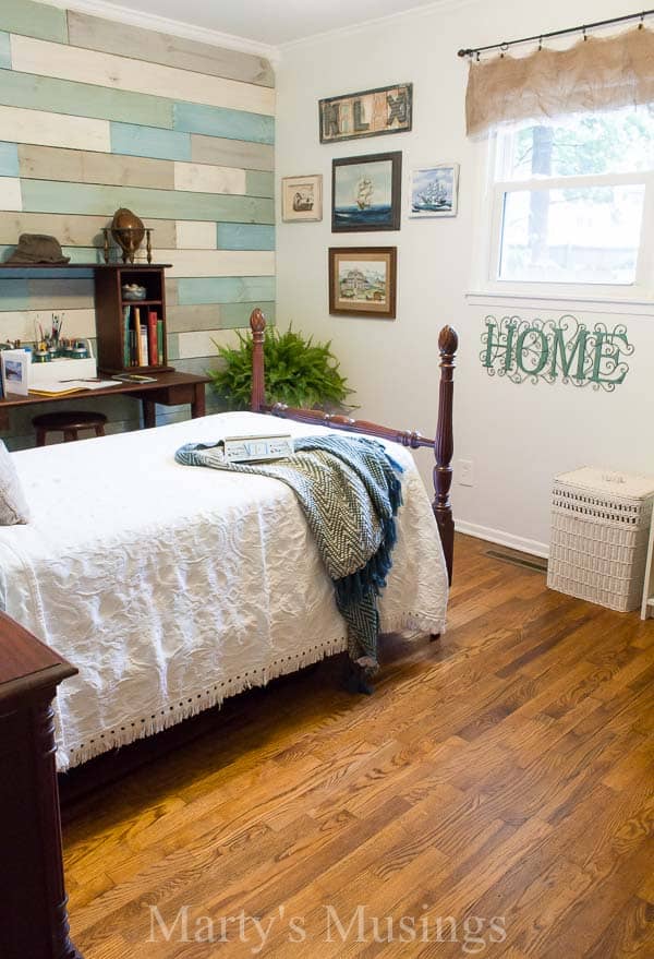 A bedroom with a bed and desk in a room