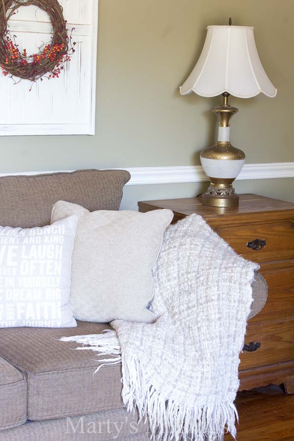 A bedroom with a lamp on a table