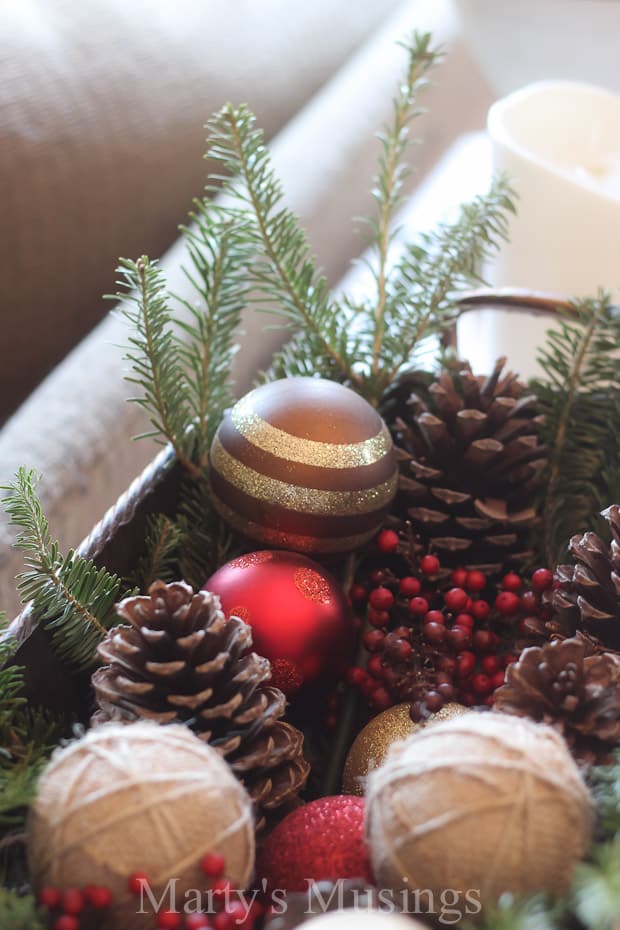 Container filled with ornaments, greenery and berries