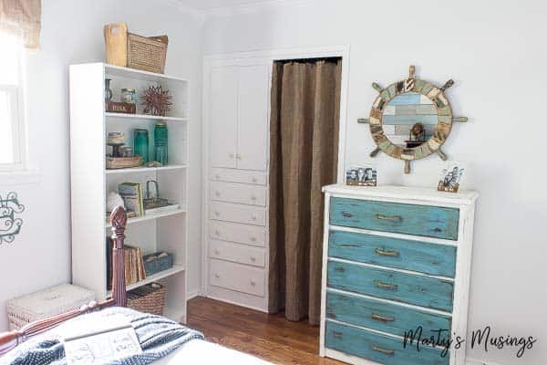 Coastal style bedroom with blue chalk painted dresser and accessories