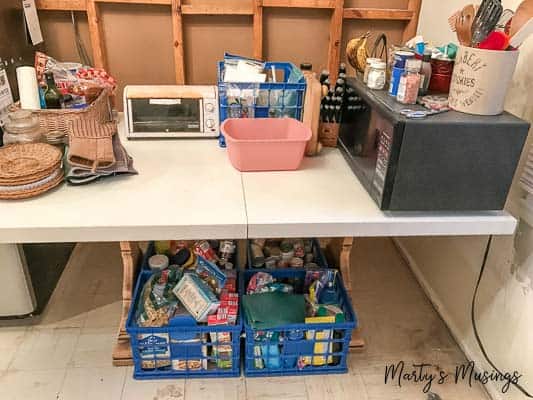 Temporary kitchen on table with appliances and food storage