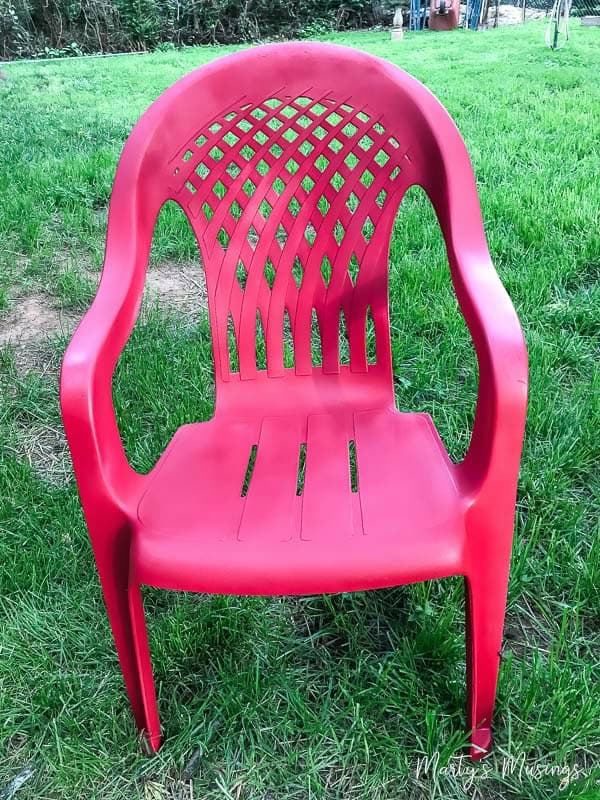 painted red plastic chair in yard