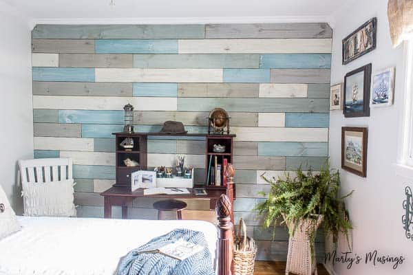 A bedroom with plank wall chalk painted different shades of blue